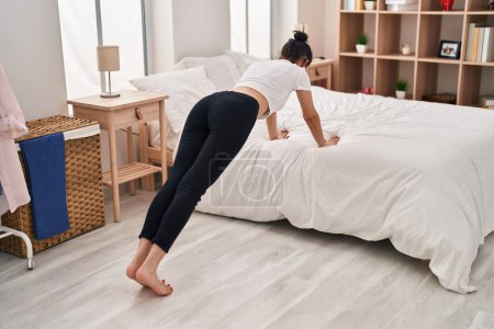Photo for Young caucasian woman training push up at bedroom - Royalty Free Image
