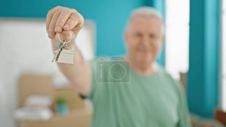 Photo for Middle age grey-haired man smiling confident holding keys at new home - Royalty Free Image