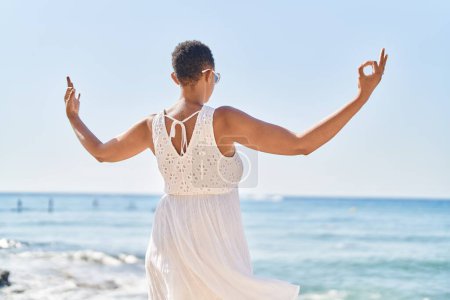 Téléchargez les photos : African american woman doing yoga exercise at seaside - en image libre de droit