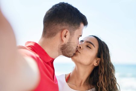 Téléchargez les photos : Jeune couple hispanique faire selfie par la caméra baisers au bord de la mer - en image libre de droit