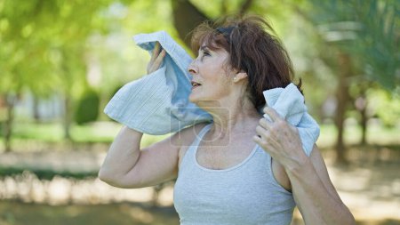 Foto de Mujer de mediana edad que usa ropa deportiva sudando en el parque - Imagen libre de derechos