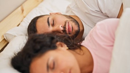 Photo for Man and woman couple lying on bed sleeping at bedroom - Royalty Free Image