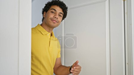 Photo for Young latin man smiling confident asking for coming at home - Royalty Free Image