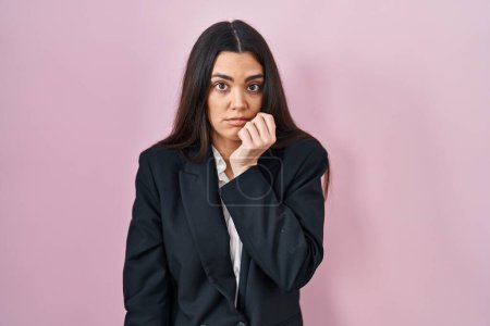 Photo for Young brunette woman wearing business style over pink background looking stressed and nervous with hands on mouth biting nails. anxiety problem. - Royalty Free Image
