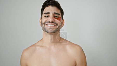 Foto de Joven hombre hispano de pie sin camisa poniendo ojos holgados parche sobre fondo blanco aislado - Imagen libre de derechos