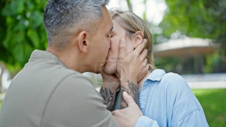 Téléchargez les photos : Homme et femme couple debout ensemble baisers au parc - en image libre de droit