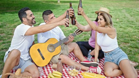 Téléchargez les photos : Groupe de personnes trinquant avec bouteille de bière pique-niquer au parc - en image libre de droit