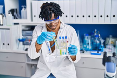 Foto de Hombre científico afroamericano sosteniendo tubos de ensayo en laboratorio - Imagen libre de derechos