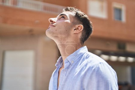 Téléchargez les photos : Young hispanic man smiling confident looking to the sky at street - en image libre de droit