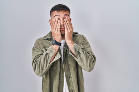 Photo for Young hispanic man standing over isolated background rubbing eyes for fatigue and headache, sleepy and tired expression. vision problem - Royalty Free Image