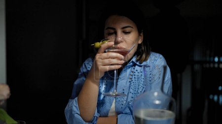Foto de Joven mujer hispana hermosa bebiendo una bebida de cóctel tropical en el restaurante - Imagen libre de derechos