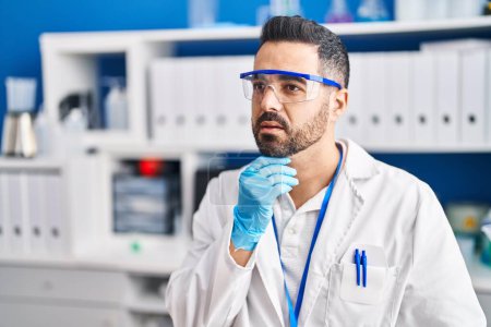 Photo for Young hispanic man scientist with doubt expression at laboratory - Royalty Free Image