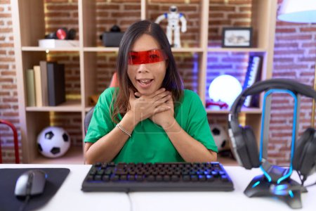 Foto de Mujer china de mediana edad que lleva gafas de realidad virtual gritando y sofocar porque estrangulamiento doloroso. problema de salud. concepto de asfixia y suicidio. - Imagen libre de derechos