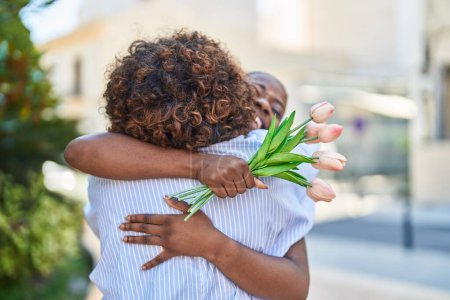 Téléchargez les photos : African american women mother and daughter surprise with bouquet of flowers at park - en image libre de droit