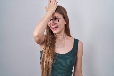 Photo for Young caucasian woman standing over white background surprised with hand on head for mistake, remember error. forgot, bad memory concept. - Royalty Free Image