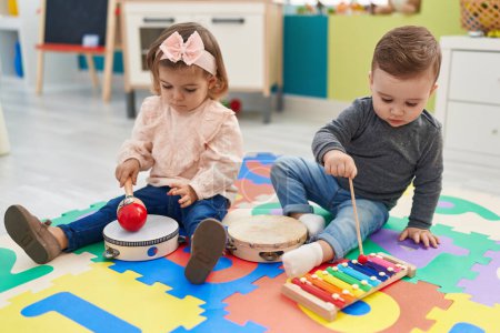 Téléchargez les photos : Adorable garçon et fille jouant xylophone et tambourin à la maternelle - en image libre de droit