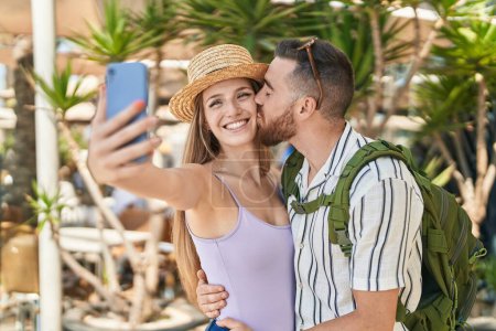 Photo for Man and woman tourist couple make selfie by smartphone kissing at street - Royalty Free Image