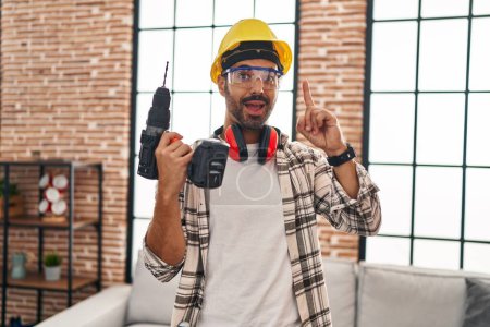 Photo for Young hispanic man with beard working at home renovation surprised with an idea or question pointing finger with happy face, number one - Royalty Free Image