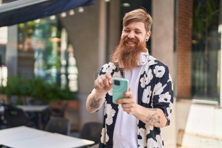Téléchargez les photos : Young redhead man smiling confident using smartphone at street - en image libre de droit