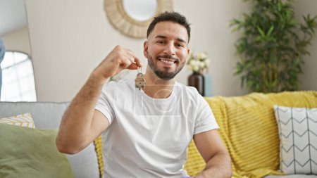 Photo for Young arab man smiling confident holding new house keys at home - Royalty Free Image