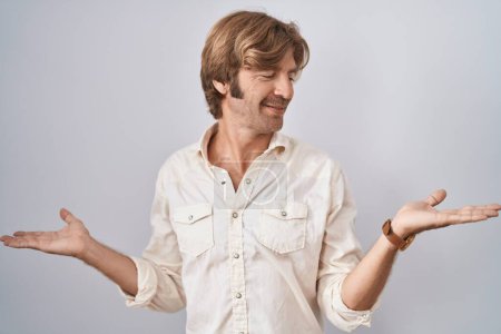 Foto de Hombre de mediana edad de pie sobre un fondo aislado sonriendo mostrando ambas manos palmas abiertas, presentando y comparando publicidad y equilibrio - Imagen libre de derechos