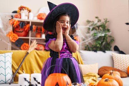 Photo for Adorable hispanic girl having halloween party with surprise expression at home - Royalty Free Image