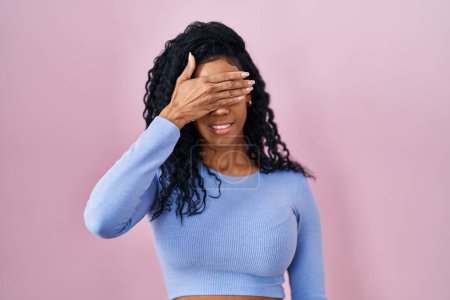 Photo for Middle age hispanic woman standing over pink background smiling and laughing with hand on face covering eyes for surprise. blind concept. - Royalty Free Image