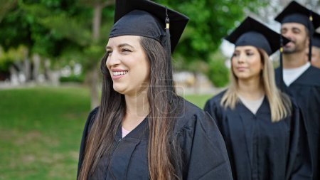Foto de Grupo de personas estudiantes graduados sonriendo confiados de pie juntos en el campus universitario - Imagen libre de derechos