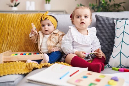 Téléchargez les photos : Adorables filles jouer avec abaque tenant des ciseaux à la maison - en image libre de droit