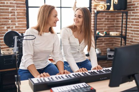 Photo for Two women musicians playing piano at music studio - Royalty Free Image