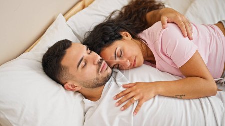Foto de Hombre y mujer pareja acostados en la cama abrazándose el uno al otro durmiendo en el dormitorio - Imagen libre de derechos