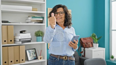 Photo for Middle age hispanic woman business worker smiling confident using smartphone at the office - Royalty Free Image