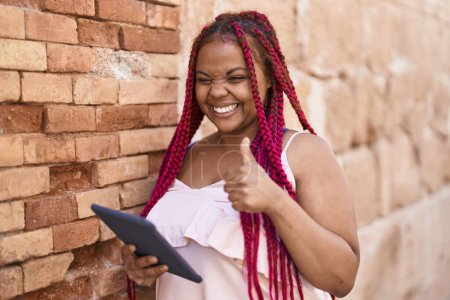 Foto de Mujer afroamericana sonriendo confiada usando touchpad en la calle - Imagen libre de derechos