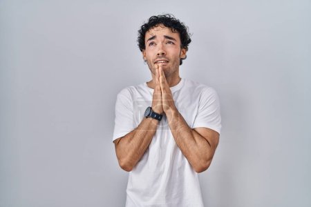 Photo for Hispanic man standing over isolated background begging and praying with hands together with hope expression on face very emotional and worried. begging. - Royalty Free Image