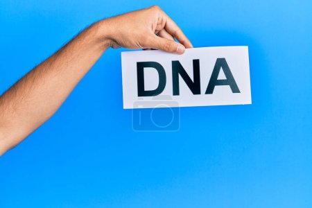 Photo for Hand of caucasian man holding paper with dna word over isolated white background - Royalty Free Image
