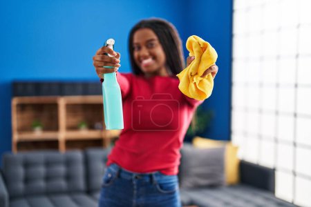 Photo for African american woman smiling confident holding sprayer and cloth at home - Royalty Free Image
