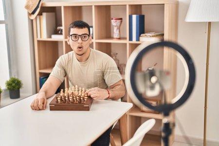Photo for Young arab man doing chess tutorial scared and amazed with open mouth for surprise, disbelief face - Royalty Free Image