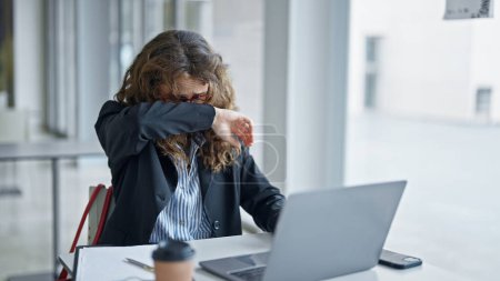 Foto de Trabajadora de negocios joven usando laptop estornudando en la oficina - Imagen libre de derechos