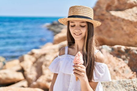 Photo for Adorable girl tourist smiling confident eating ice cream at seaside - Royalty Free Image