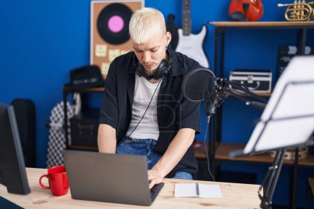 Téléchargez les photos : Young caucasian man artist using laptop at music studio - en image libre de droit