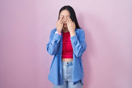 Téléchargez les photos : Jeune femme asiatique debout sur fond rose frottant les yeux pour la fatigue et les maux de tête, somnolent et l'expression fatiguée. problème de vision - en image libre de droit