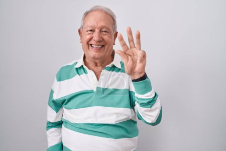 Téléchargez les photos : Homme âgé avec les cheveux gris debout sur fond blanc montrant et pointant vers le haut avec les doigts numéro trois tout en souriant confiant et heureux. - en image libre de droit
