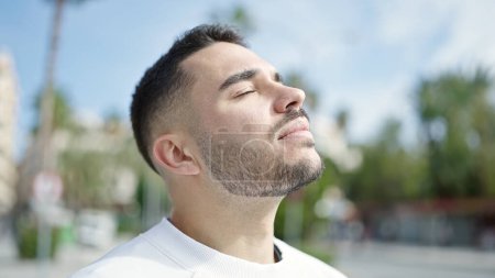 Photo for Young hispanic man breathing with closed eyes at street - Royalty Free Image