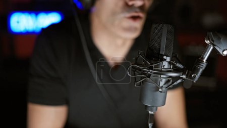 Téléchargez les photos : Jeune homme hispanique parlant dans une émission de radio au studio de radio - en image libre de droit