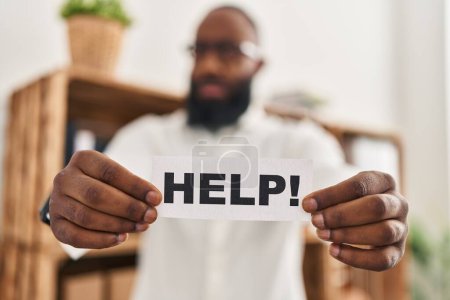 Photo for African american man holding help reminder clueless and confused expression. doubt concept. - Royalty Free Image