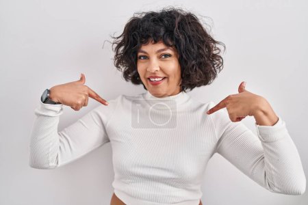 Photo for Hispanic woman with curly hair standing over isolated background looking confident with smile on face, pointing oneself with fingers proud and happy. - Royalty Free Image