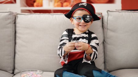 Téléchargez les photos : Adorable garçon hispanique portant costume de pirate tenant doux à la maison - en image libre de droit