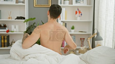 Photo for Young hispanic man waking up stretching head at bedroom - Royalty Free Image