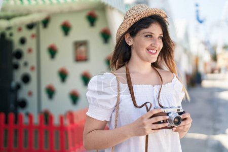 Foto de Young hispanic woman tourist smiling confident using camera at street - Imagen libre de derechos