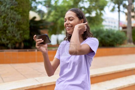 Téléchargez les photos : Young african american woman smiling confident watching video on smartphone at park - en image libre de droit